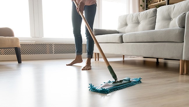 Barefoot woman cleaning floor with wet mop pad | Dehart Tile