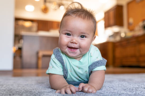 Baby laying on carpet floorings | Dehart Tile