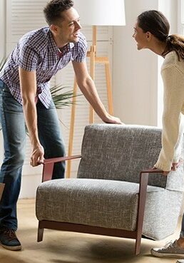 Couple carrying chair together | Dehart Tile